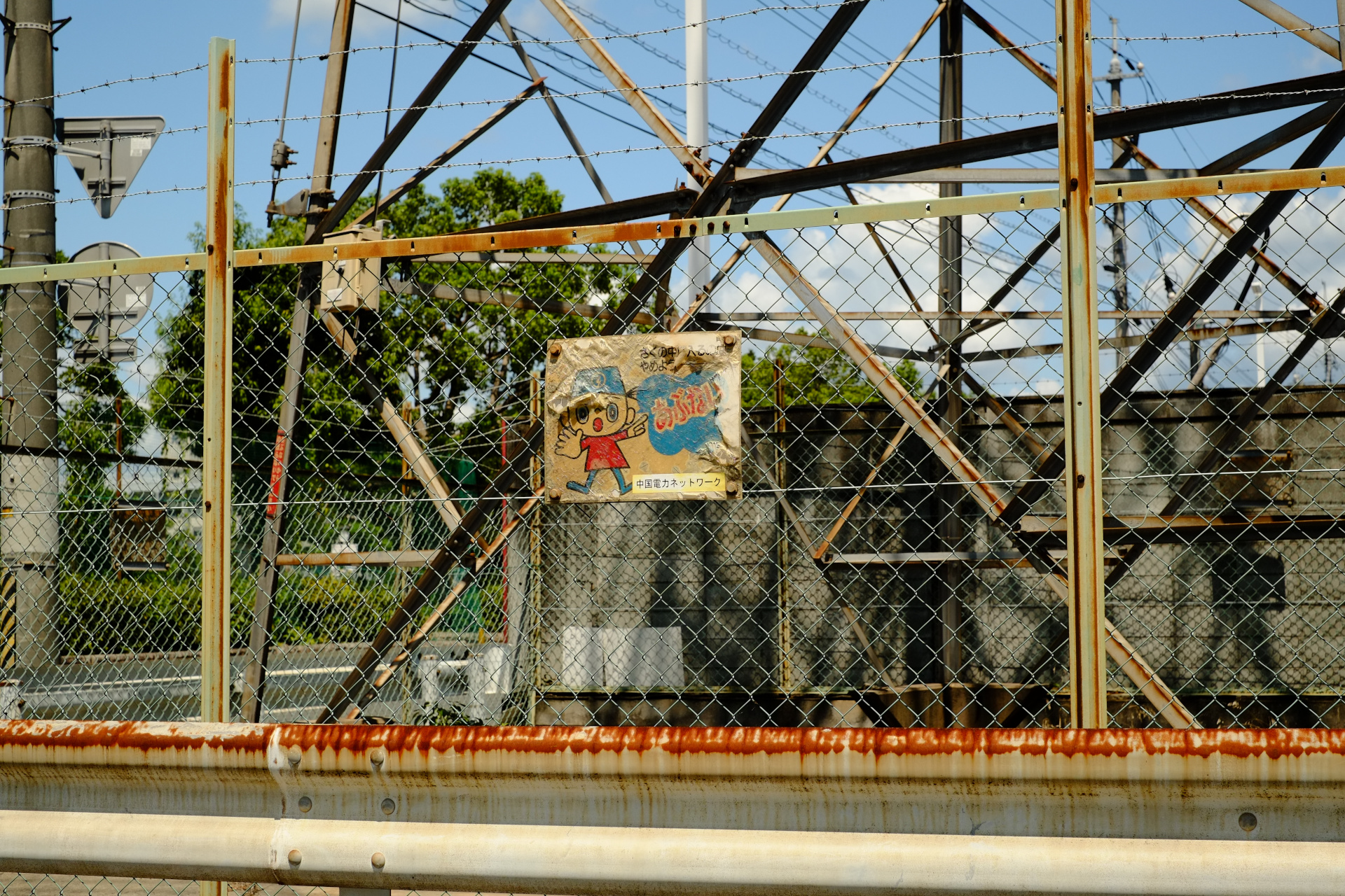 Faded poster behind a rusty fence