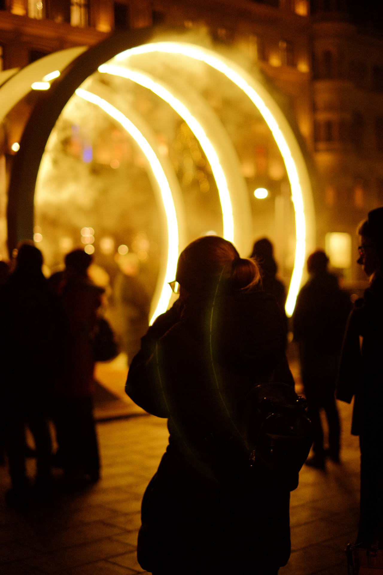 Silhouettes under a glowing neon ring